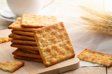 Heap of Dry thin crispy crackers on cutting board on wood table