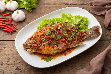 Three Flavoured Deep fried Fish,Fried fish with chili garlic and palm sugar,spicy sweet sauce in white plate (Pla Rad Prik)