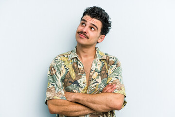 Young caucasian man isolated on blue background dreaming of achieving goals and purposes