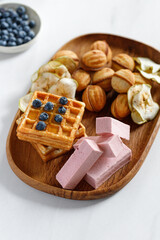 Wooden dish with sweets, waffles and pastilles. Natural sweets. Apple chips.