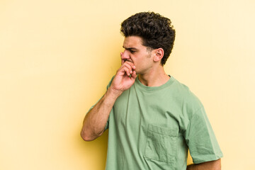 Young caucasian man isolated on yellow background keeping a secret or asking for silence.