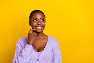 Photo of minded positive girl finger touch chin look interested empty space isolated on yellow...