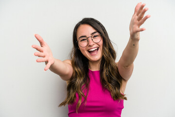 Young caucasian woman isolated on white background feels confident giving a hug to the camera.