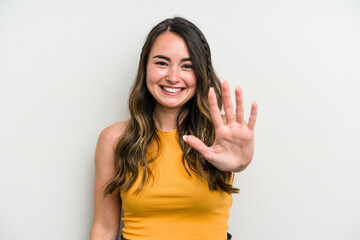 Young caucasian woman isolated on white background smiling cheerful showing number five with fingers.