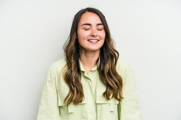 Obraz premium Young caucasian woman isolated on white background laughs and closes eyes, feels relaxed and happy.