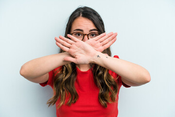Young caucasian woman isolated on blue background doing a denial gesture
