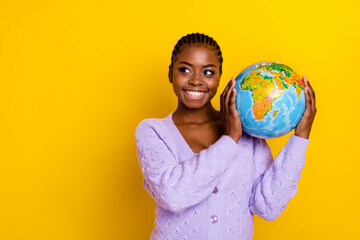 Photo of pretty positive lady hands hold globe look empty space isolated on yellow color background