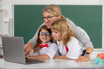 School pupil with teacher learning at laptop computer, studying with online education e-learning in...