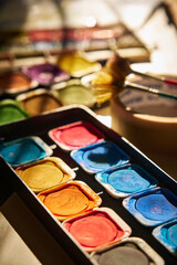 watercolor paints are laid out on the table