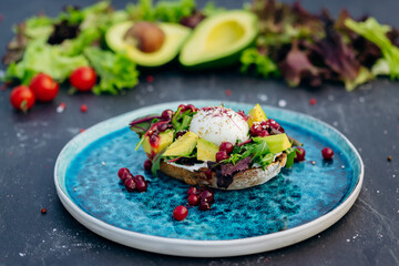 Whole wheat toasted bread with avocado, poached egg, soft cheese and mix salad. Healthy diet food breakfast