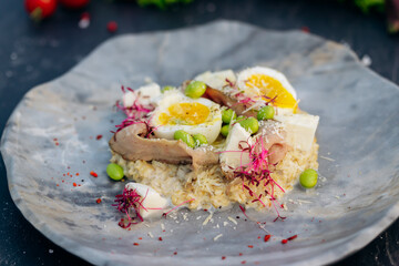 Oatmeal with boiled egg, bacon and green peas. Healthy and tasty breakfast