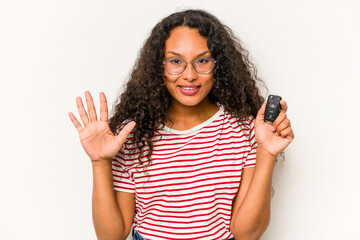 Young hispanic woman holding car keys isolated on white background smiling cheerful showing number five with fingers.