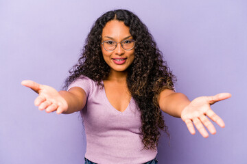 Young hispanic woman isolated on purple background showing a welcome expression.