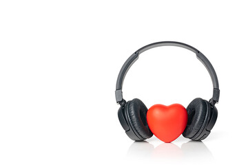 Fototapeta na wymiar Black wireless headphones with red heart isolated on white background. Listen to your heart music of love. Copy space.