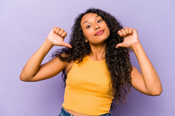 Young hispanic woman isolated on purple background feels proud and self confident, example to...