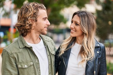 Fototapeta premium Man and woman couple smiling confident hugging each other at street
