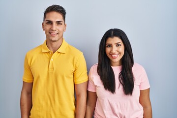 Fototapeta premium Young couple standing over isolated background with a happy and cool smile on face. lucky person.