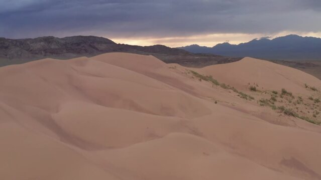 Beautiful sand dune in the wild at sunset. Aerial footage of The Singing Dune, or Aigaikum in Altyn-Emel National Park.