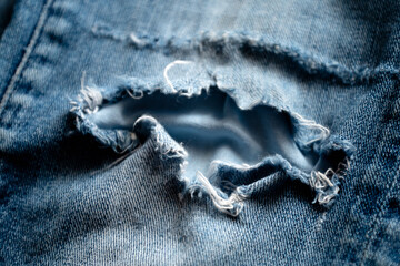 old blue jeans torn at the knee close up