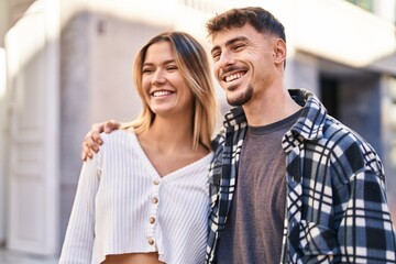 Naklejka premium Young man and woman couple hugging each other standing at street