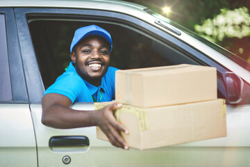 African delivery man holding a box package in the car with smile and happy.Concept of business...