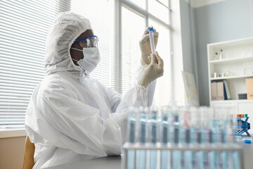 Close up of female scientist wearing full protective gear while performing research with hazardous...
