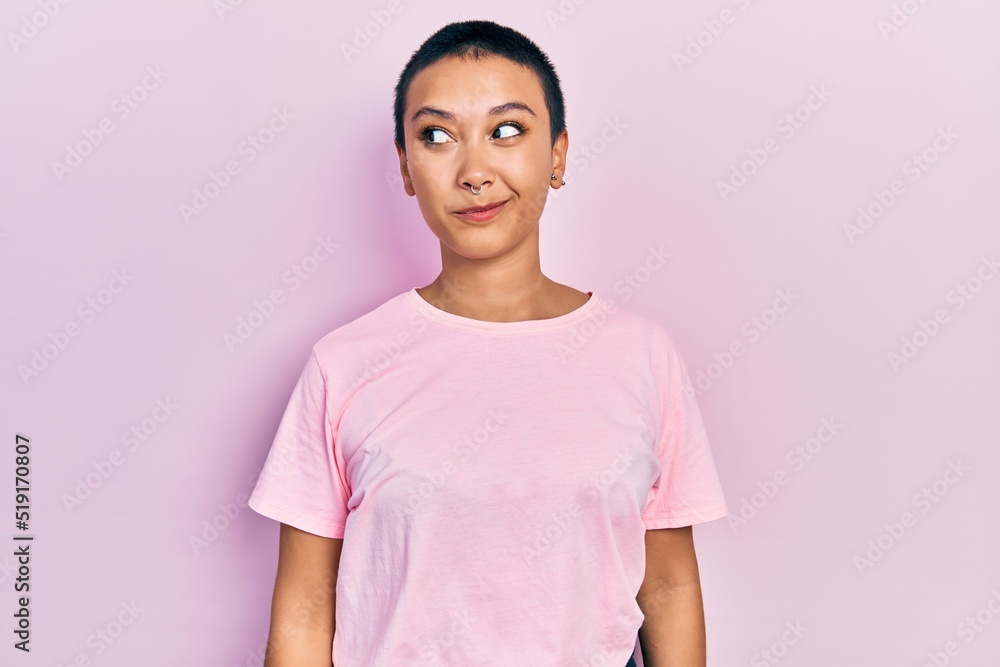 Poster Beautiful hispanic woman with short hair wearing casual pink t shirt smiling looking to the side and staring away thinking.