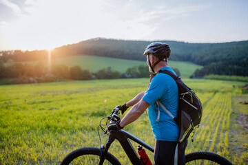Fototapeta premium Active senior man riding bicycle at summer park, healthy lifestyle concept.