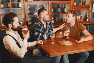 Three men in shirts in the bar.