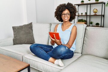 Young african american woman smiling confident using touchpad at home