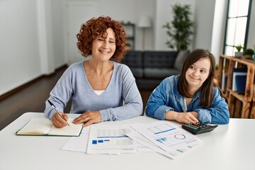 Mature mother and down syndrome daughter doing economy house together