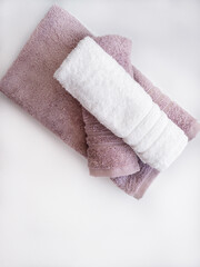 Twisted pink and white towels on the white background.