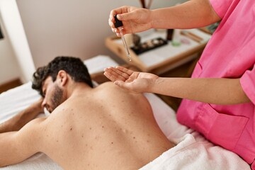 Obraz na płótnie Canvas Man reciving back massage with oil at beauty center.