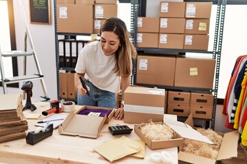 Young hispanic woman smiling confident packing order at store