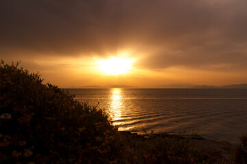 Fototapeta na wymiar Sunset on the beach, cloudy sky in Greece, Aegean sea