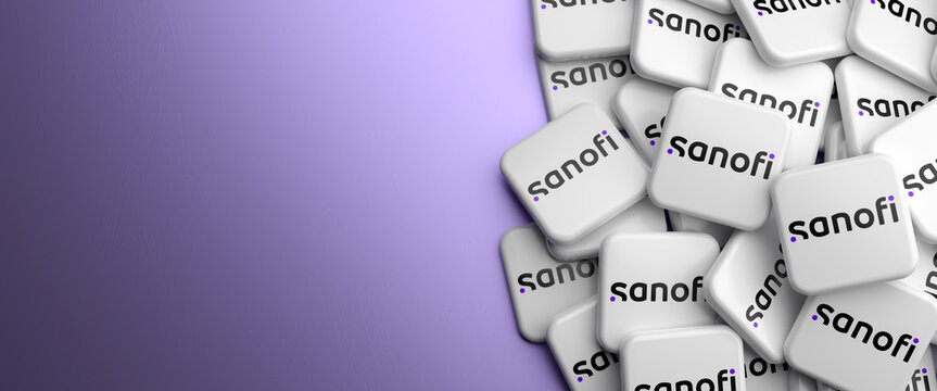Logos of the French pharmaceutical and healthcare company Sanofi on a heap on a table. Copy space. Web banner format.