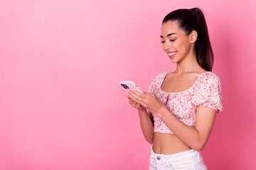 Portrait of pretty cheerful girl hold use telephone chatting empty space isolated on pink color background