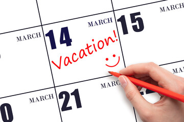 14th day of March. A hand writing a VACATION text and drawing a smiling face on a calendar date 14...