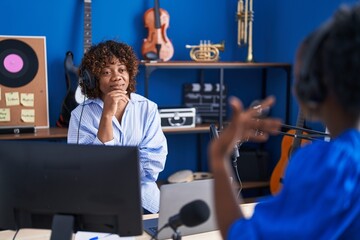 African american women musicians smiling confident speaking at music studio