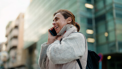 Fototapeta premium Middle age hispanic woman smiling confident talking on the smartphone at street