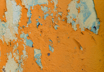 grunge texture of an old wall with peeling bright orange paint