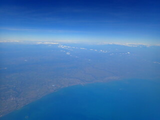 beautiful view over the cloud, blue sky, sea and mainland from air plane window
