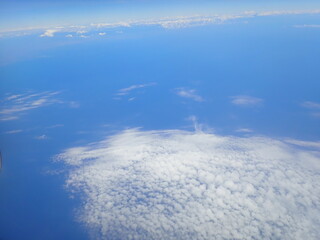 beautiful view over the cloud, blue sky and sea from air plane window