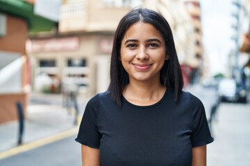 Young latin woman smiling confident standing at street