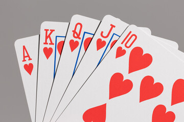Close-up of poker hand showing royal flush in hearts