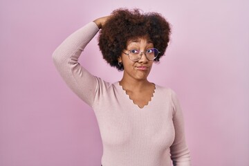 Young african american woman standing over pink background confuse and wondering about question....