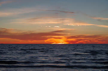 Colorful orange sunset over Baltic sea on clear summer day
