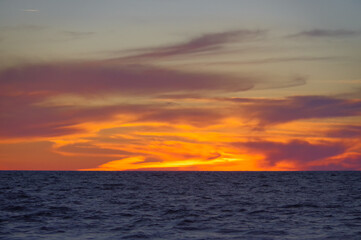 Obraz premium Colorful orange sunset over Baltic sea on clear summer day 