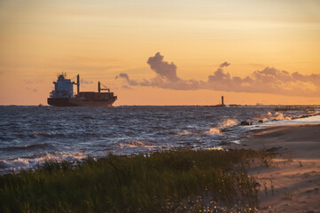 Fototapeta premium Ship leaving the harbor on sunny and clear sunny evening