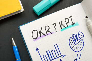 Marks in the notepad OKR or KPI and business charts.